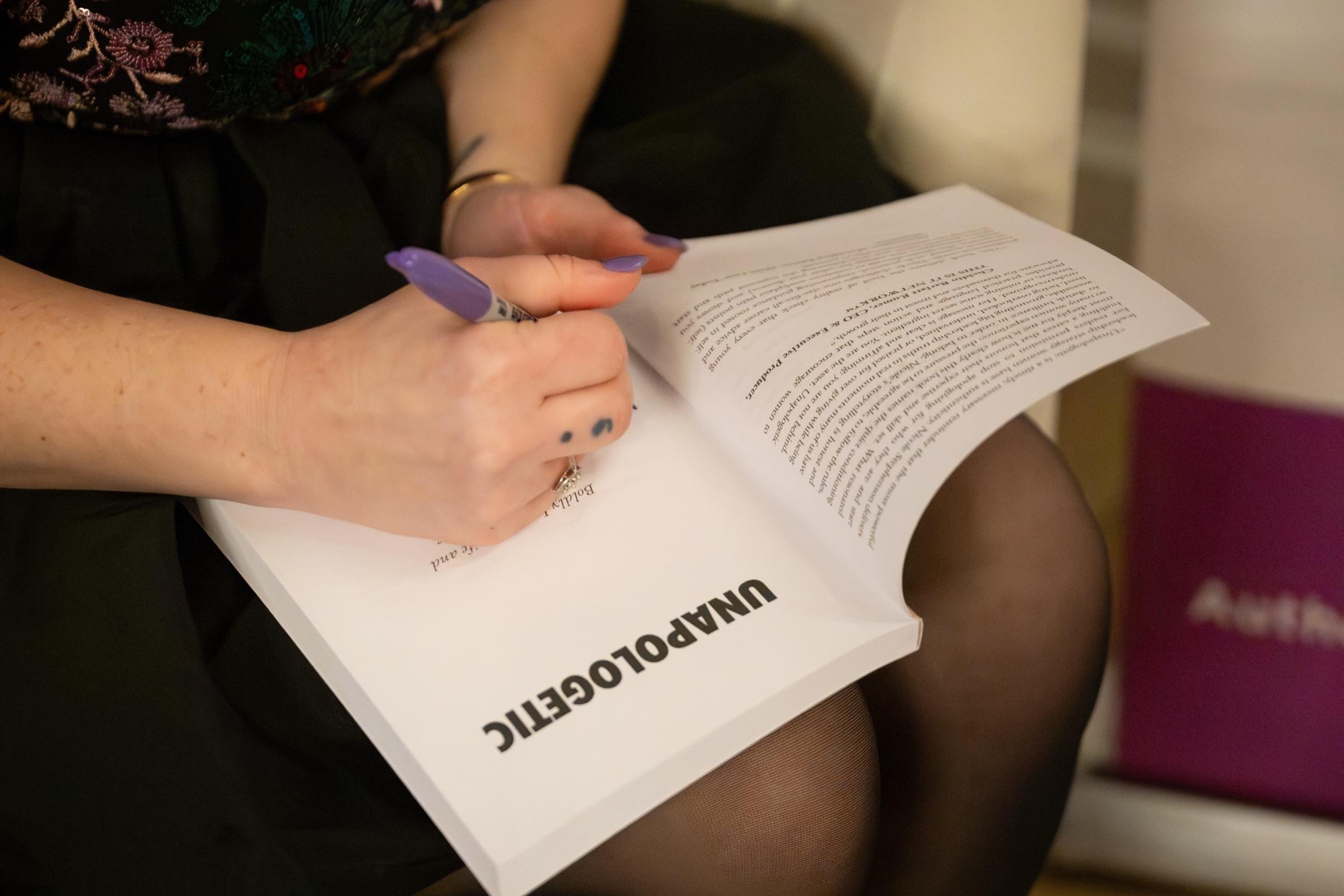 Close-up of Nicole signing a copy of Unapologetic at the launch event.